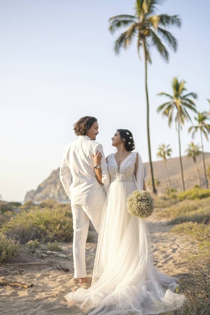 Mariana y Andrés en la playa entre palmeras